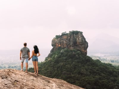 A couple in love on a rock admires the beautiful views. A couple in love travels