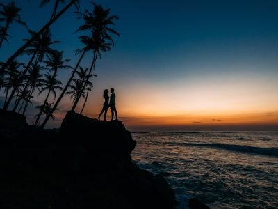 Silhouette of loving couple on sea. Man and woman at sunset. Honeymoon on the Islands. Man and woman meet sunset. Happy loving couple. Silhouette lovers. Wedding travel. Loving couple. Honeymoon trip