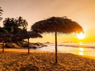 two-beach-umbrellas-at-sunrise-on-a-sandy-beach-t-2023-11-27-05-13-00-utc