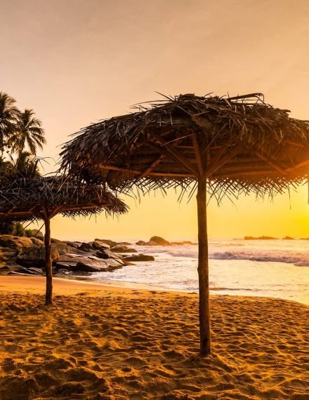 two-beach-umbrellas-at-sunrise-on-a-sandy-beach-t-2023-11-27-05-13-00-utc